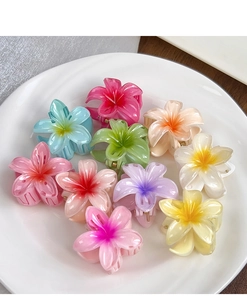 Détail de pinces à cheveux en forme de fleurs en résine colorée sur un plateau