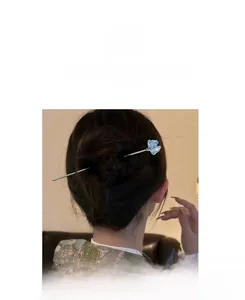 Elegant silver hair pin with a light blue flower pendant worn in a modern bun hairstyle
