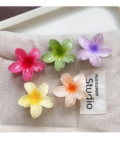Détail macro de pinces à cheveux élégantes en forme de fleurs dans cinq couleurs pastel