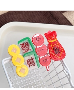 Close-up of Chinese New Year hair clips featuring Lucky Bag and Mahjong tile charms