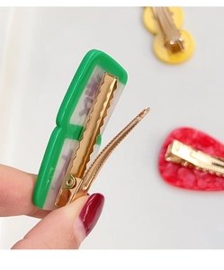 Detailed back view of acrylic hair clips showing golden metal duckbill clip with anti-slip teeth