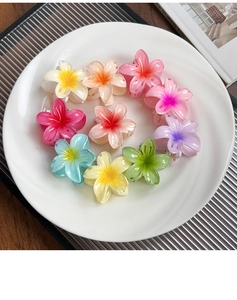 Vue détaillée de petites pinces à cheveux en forme de fleur de frangipanier colorée