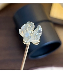 Macro shot of translucent white camellia hair pin with detailed gold filigree base