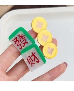 Close-up of festive hair clips featuring mahjong tiles and ancient gold coins