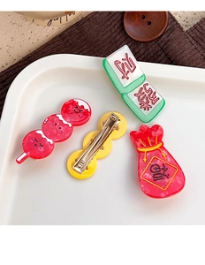 Close-up of festive hair clips featuring Lucky Bag, Tanghulu, and Mahjong tile designs