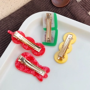 Festive Chinese New Year hair clip set with mahjong and goldfish designs on white ceramic