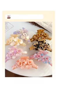 Détail de grandes pinces à cheveux fleur en acétate avec sept motifs colorés variés