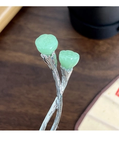 Detailed macro view of neo-Chinese hair stick with green lotus pod and silver branch
