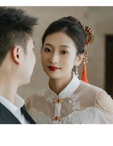 Detail of red jewel button and lace collar on traditional Chinese bridal gown