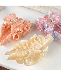 Trois pinces à cheveux fleur en acétate coloris corail, bleu marbré et beige nacré