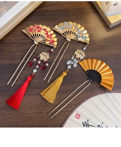 Detail of traditional Chinese fan-shaped hairpins with floral motifs and silk tassels