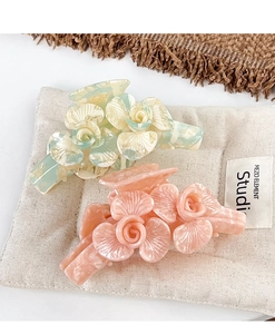 Détails des pinces à cheveux à fleurs en acétate avec texture marbrée sur lin