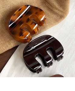 Close-up of amber tortoiseshell and dark brown glossy hair claw clips for daily styling