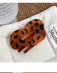 Détail de la pince à cheveux en forme de cœur avec motif léopard et fini ambre