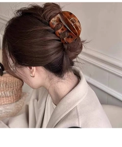Detail view of large tortoiseshell hair claw clip securing an elegant updo hairstyle