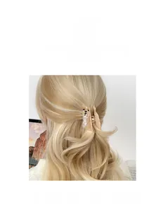Détail d'une pince à cheveux carlin effet ambre sur des cheveux blonds bouclés