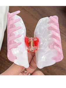 Macro shot of pink and white acetate butterfly hair claw with clear red spring