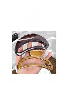 Close-up of wood grain textured large hollow hair claw clips in brown and tan