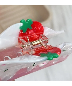 Detail of strawberry hair claw clip showing durable metal spring and red acrylic material