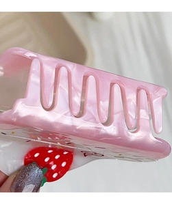 Close-up of pink marble acetate hair claw clip with delicate red strawberry detail