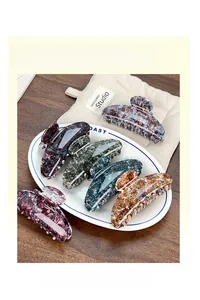 Detail showing various marbled semi-circle shark hair claw clips in different colors