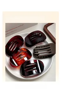 Barrettes ovales plates en écaille de tortue et fini mat sur assiette en porcelaine