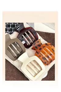 Lot de quatre pinces à cheveux trapézoïdales mates et écailles sur fond en tissu