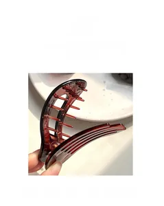 Détail de la pince à cheveux ambre mate avec structure multi-dents et style rétro