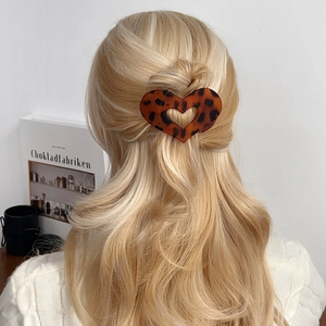 Pince à cheveux minimaliste en forme de cœur avec motif léopard portée par un modèle