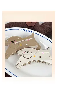 Close-up of cute cartoon puppy hair claw clips with star patterns on a white plate