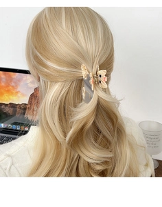 Vue détaillée d'une jolie pince à cheveux chat sur cheveux blonds pour une demi-queue