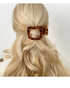 Détail d'une pince à cheveux motif léopard sur des cheveux longs blonds bouclés