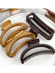 Macro shot of large wood grain hair claws in various shapes on a white ceramic tray