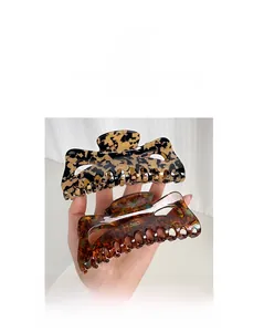 Detail view of large tortoise shell and leopard print hair claws with glossy finish