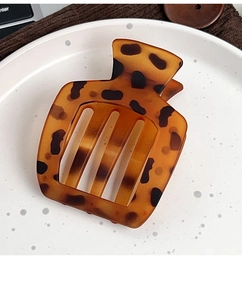 Gros plan d'une pince à cheveux motif écaille de tortue avec texture ambre élégante