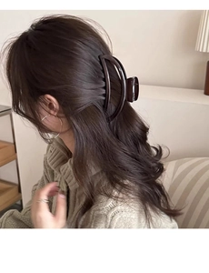 Side view of large coffee brown hair claw clip on woman's updo hairstyle