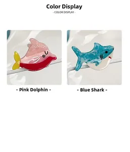 Detailansicht der kleinen Haarklammern als rosa Delphin und blauer Hai aus Harz