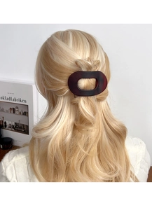 Détail d'une pince à cheveux ovale en écaille de tortue sur cheveux blonds, style français