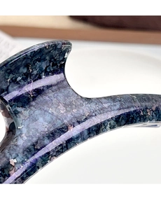 Macro shot of large hair claw clip with dark blue marble texture and glittery finish