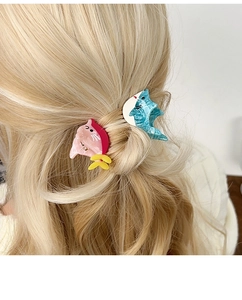 Detailaufnahme süßer Pastell-Haarspangen mit Marmorstruktur auf blondem Haar