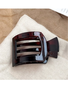Close-up of large tortoiseshell duckbill hair clip with polished dark brown resin texture