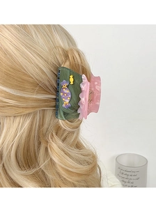 Vue détaillée de la pince à cheveux bicolore en acétate avec décors de bonbons sur cheveux