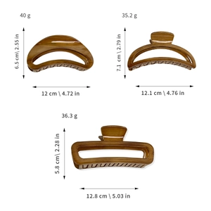Three large wood grain hair claws in amber brown with hollow rectangle and crescent designs