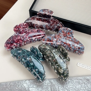 Five assorted marble texture hair claws in various colors with a high gloss finish