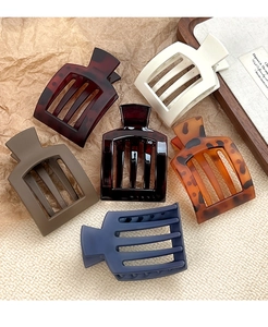 Detailed flat lay of matte square hair claws in six colors on aesthetic props