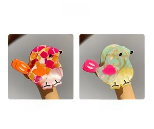 Close-up of bird-shaped acetate hair clips showing floral and marble textures