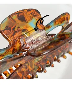 Macro shot of durable golden metal spring and tortoise shell texture on large hair claw