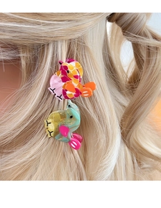 Close-up of a model wearing colorful bird-shaped acetate hair clips on blonde hair
