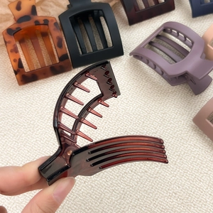 Matte and leopard print large square hollow hair claws on a textured fabric background