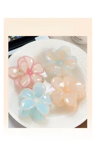 Dettaglio di quattro mollette per capelli a forma di fiore in colori gelatina pastello